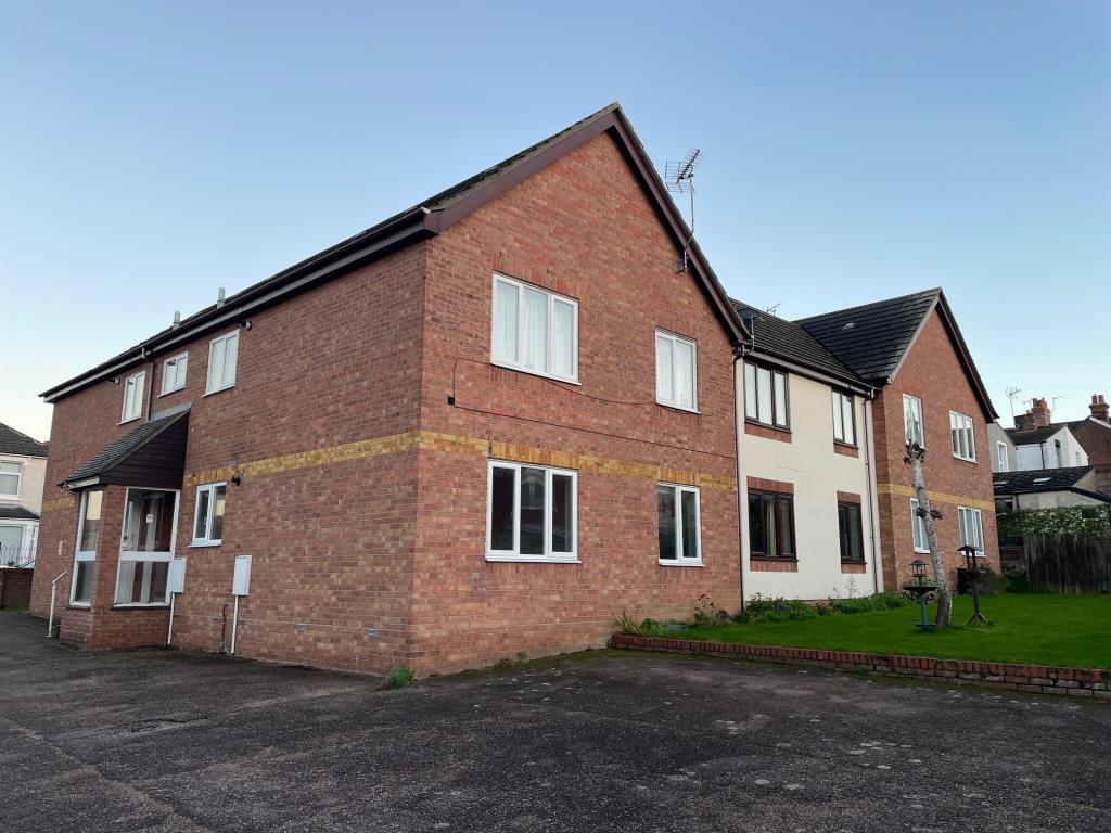 Lot: 99 - VACANT GROUND FLOOR ONE-BEDROOM FLAT IN ESSEX COASTAL TOWN - General view of the rear of the block and parking area